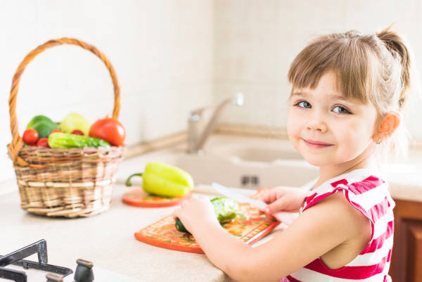 Two children enjoying a healthy lunch with fruits and vegetables in a school cafeteria.
